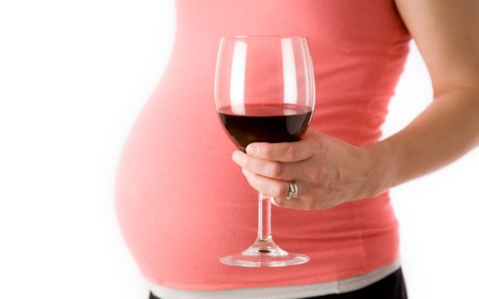 AR0PXC Pregnant Woman Holding a Glass of Wine