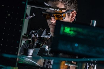 Rice University graduate student Kyle Smith checks a sample while testing the lab’s snapshot hyperspectral imaging system. Rice scientists developed the system to take instantaneous spectra of multiple plasmonic nanoparticles. Photo by Jeff Fitlow