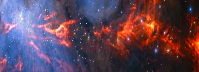 This spectacular and unusual image shows part of the famous Orion Nebula, a star formation region lying about 1350 light-years from Earth. It combines a mosaic of millimetre wavelength images from the Atacama Large Millimeter/submillimeter Array (ALMA) and the IRAM 30-metre telescope, shown in red, with a more familiar infrared view from the HAWK-I instrument on ESO’s Very Large Telescope, shown in blue. The group of bright blue-white stars at the left is the Trapezium Cluster — made up of hot young stars that are only a few million years old.