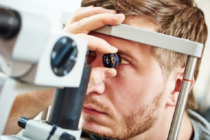 Male patient under eye vision examination in eyesight ophthalmological correction clinic