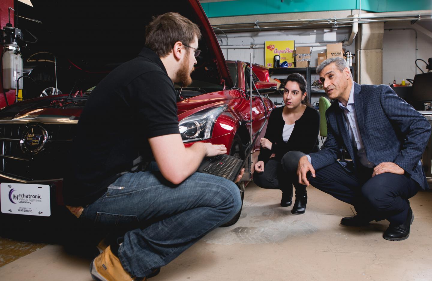 This is a photo of new valve technology that promises cheaper, greener engines, Amir Khajepour, a professor of mechanical and mechatronics engineering at Waterloo, in his lab working with his students