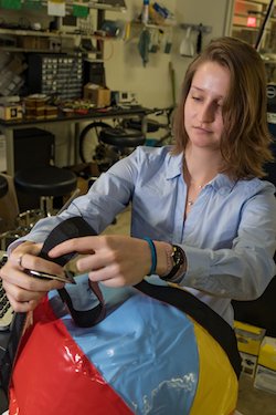 Rice University bioengineering student Catherine Schult mounts a puck-like sensor to a beach ball, which served as a stand-in for women in labor who will benefit from the contraction monitor device. Photo by Jeff Fitlow
