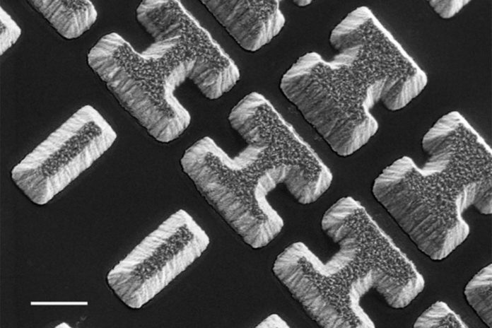 Scanning Electron Microscope image shows a few of the carefully designed shaped of the chalcogenide glass deposited on a clear substrate. The shapes, which the researchers call “meta-atoms,” determine how mid-infrared light is bent when passing through the material. Courtesy of the researchers