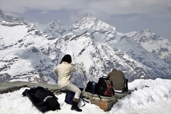 a tourist capturing photo of ice mountain