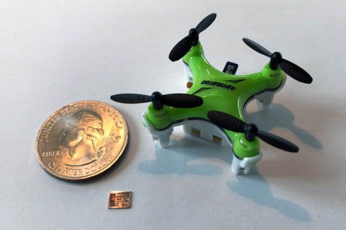 A new computer chip, smaller than a U.S. dime and shown here with a quarter for scale, helps miniature drones navigate in flight. Image courtesy of the researchers.