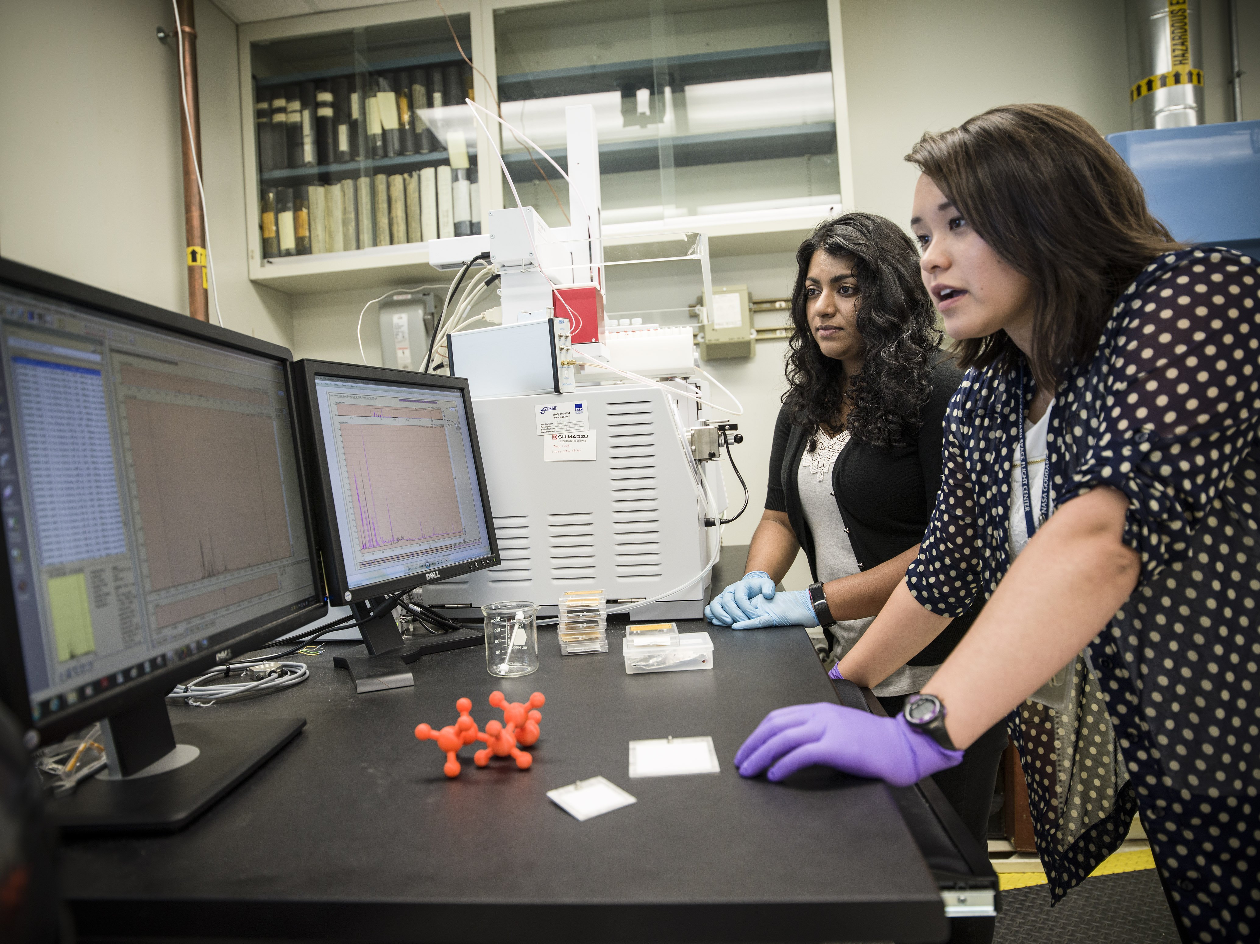 Jennifer Domanowski (forefront) and Nithin Abraham begin evaluating the effectiveness of a NASA-developed adsorber coating for removing mercury vapor and other contaminants inside Smithsonian-owned specimen-storage cabinets. Credits: Chris Gunn/NASA