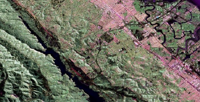 In a milestone for earthquake forecasting, researchers report that their physics-based model of California earthquake hazards replicated estimates from the state’s leading statistical model. In the above radar image, a section of California’s San Andreas fault can be seen below the Crystal Springs Reservoir (in black), with San Francisco (in pink) to the east. (Image: NASA Jet Propulsion Laboratory)