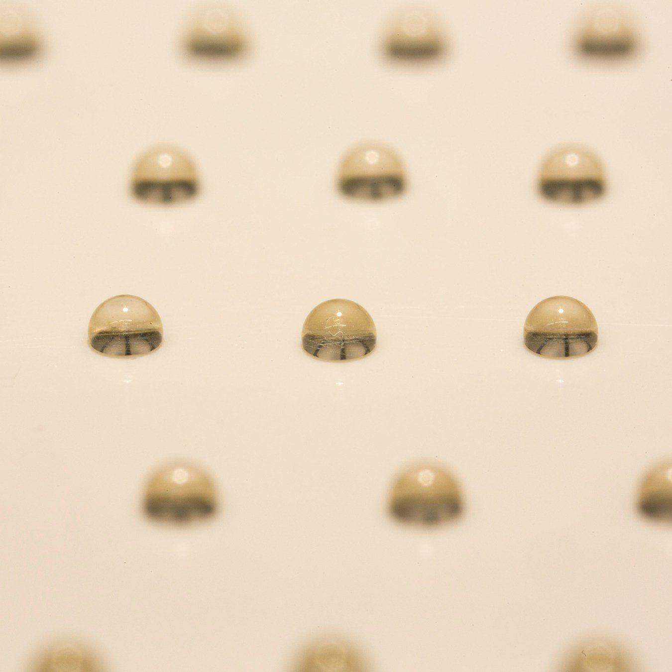 By controlling the target position, the ejected droplets can be carefully deposited and patterned anywhere. In this example, honey drops are patterned on a glass substrate