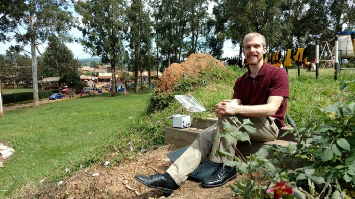 Doctoral student Ryan Snodgrass heats up the TINY diagnostic device using sunlight at the AIDS Healthcare Foundation-Uganda Cares Clinic in Masaka, Uganda, in 2017. The energy stored from the sun negates the need for electricity, which may be unreliable in such locations.