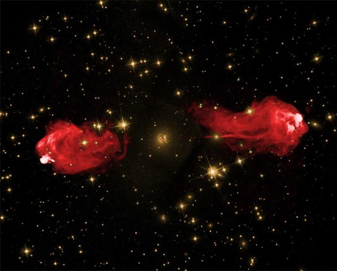 Two images of Cygnus A layered over each other to show the galaxy’s jets glowing with radio radiation (shown in red). Quiescent galaxies, like our own Milky Way, do not have jets like this, which may be related to magnetic fields. The yellow image shows background stars and the center of the galaxy shrouded in dust when observed with visible light. The area SOFIA observed is inside the small red dot in the center. Credits: Optical Image: NASA/STSiC Radio Image: NSF/NRAO/AUI/VLA