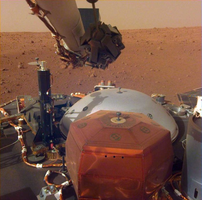 This image from InSight's robotic-arm mounted Instrument Deployment Camera shows the instruments on the spacecraft's deck, with the Martian surface of Elysium Planitia in the background.