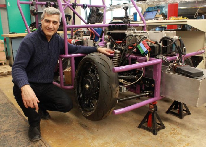 Prof. Amir Khajepour stands next to a vehicle containing his new wheel unit. CREDIT University of Waterloo