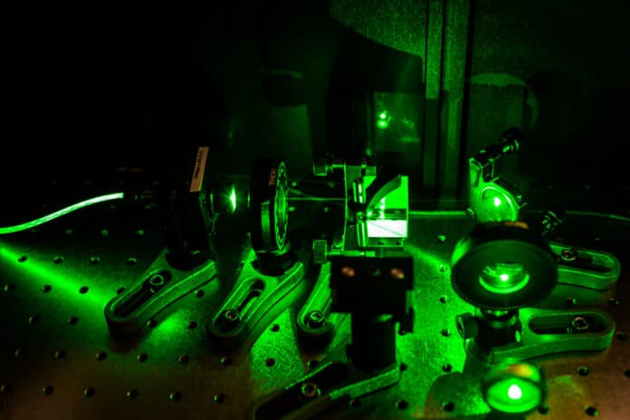 The experimental setup used by the researchers to test their magnetic sensor system, illuminated by green laser light.
