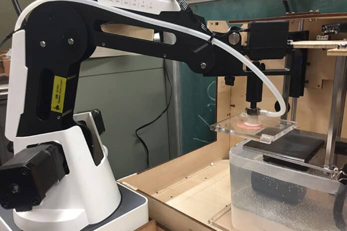 Robotic arm stacking layers of 2D tissues