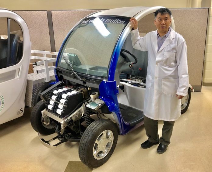 Xianguo Li with a fuel cell test vehicle in his lab.