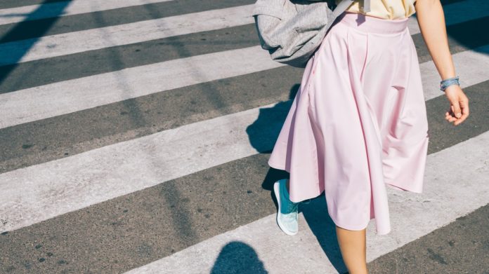 Women wearing pink skirt, walking on street with blue shoes