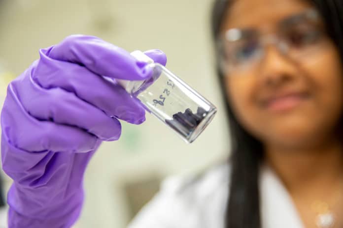 Lead researcher Aindrila Mukhopadhyay holds a vial of purified indigoidine crystals. Image: Berkeley Lab