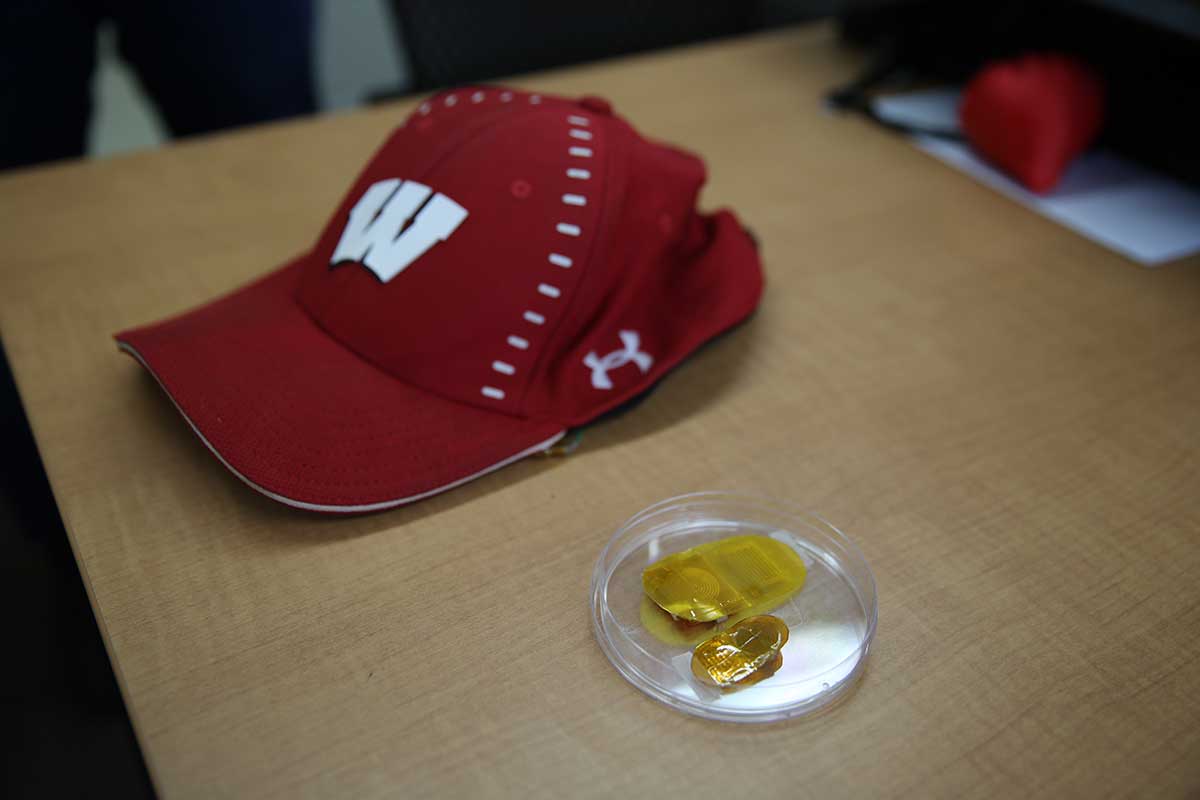 The device, right, is shown along with a baseball cap used to cover it. UW-MADISON PHOTO BY ALEX HOLLOWAY