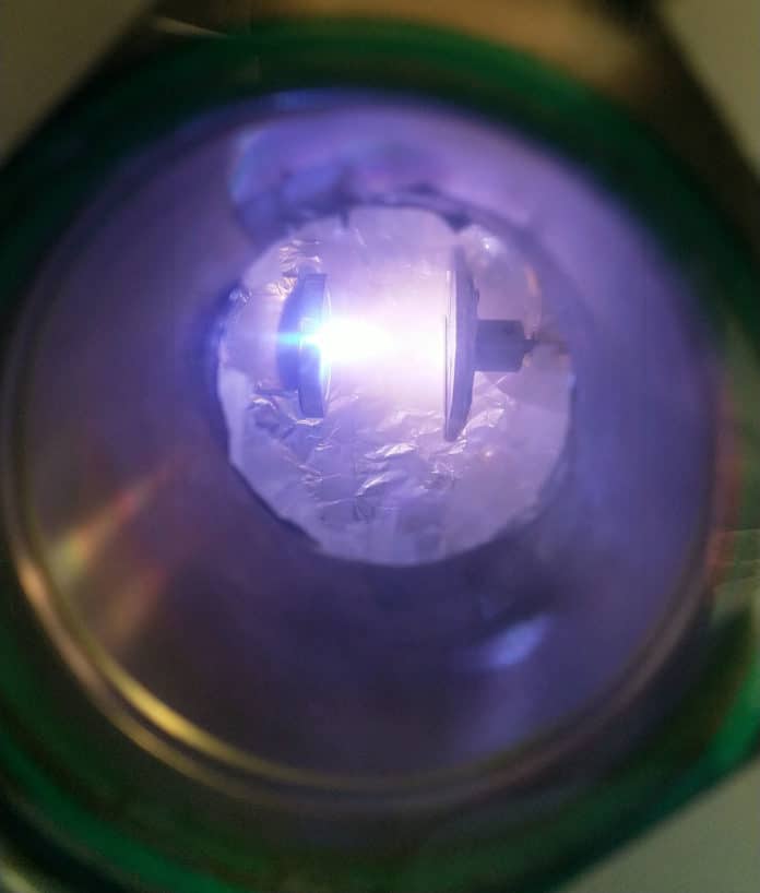 Method used to produce the ductile glass. Pulsed laser deposition: highly energetic laser pulses are shot to the crystalline target on the left side of the image. The intense energy breaks down the crystalline aluminum oxide into purple colored plasma, which injects outwards at high speed. The plasma cools down extremely fast to form a film of glassy (amorphous) aluminum oxide upon colliding with the substrate on the right side of the image. Credit: Erkka Frankberg