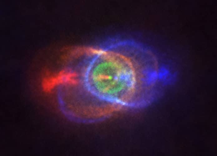 This new ALMA image shows the outcome of a stellar fight: a complex and stunning gas environment surrounding the binary HD101584. The colours represent speed, going from blue — gas moving the fastest towards us — to red — gas moving the fastest away from us. Jets, almost along the line of sight, propel the material in blue and red. The stars in the binary are located at the single bright dot at the centre of the ring-like structure shown in green, which is moving with the same velocity as the system as a whole along the line of sight. Astronomers believe this ring has its origin in the material ejected as the lower mass star in the binary spiralled towards its red-giant partner.