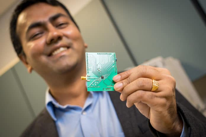 UC San Diego electrical and computer engineering professor Dinesh Bharadia holds a PCB onto which the Wi-Fi radio is mounted.