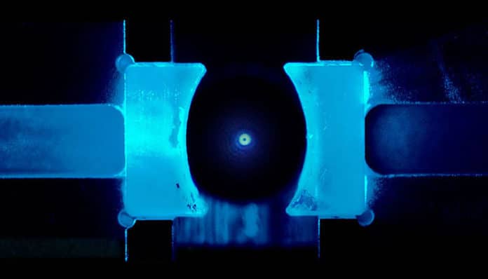 Researchers cooled a levitated nanoparticle to the quantum groundstate for the first time. This work was made possible by the recent breakthrough application of coherent scattering in the field of cavity optomechanics. (© Lorenzo Magrini, Yuriy Coroli/University of Vienna)