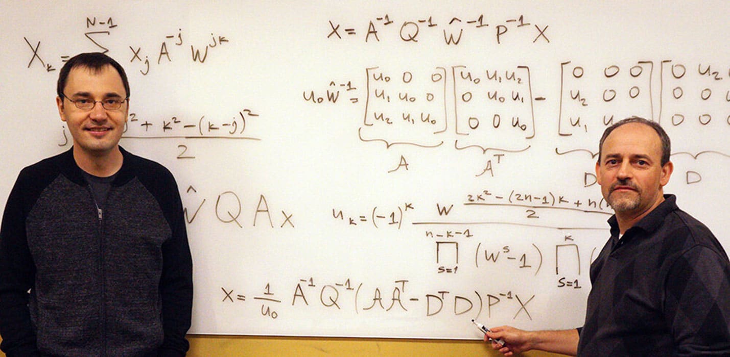 Vladimir Sukhoy and Alexander Stoytchev, left to right, with the derivation for the ICZT algorithm in structured matrix notation -- the answer to a 50-year-old puzzle in signal processing. Photo by Paul Easker.