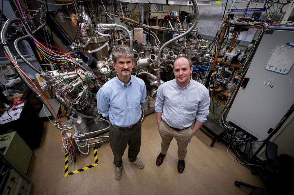 David Storm, a research physicist, and Tyler Growden, a National Research Council postdoctoral researcher, at the U.S. Naval Research Laboratory with their molecular beam epitaxy system that develops gallium nitride-based (GaN) semiconductors in Washington, D.C., March 10, 2020. Storm and Growden published their research on GaN semiconductor materials, which showed high yield and performance well suited for high frequency and high power electronic devices in Applied Physics Letters. U.S. Navy photo by Jonathan Steffen