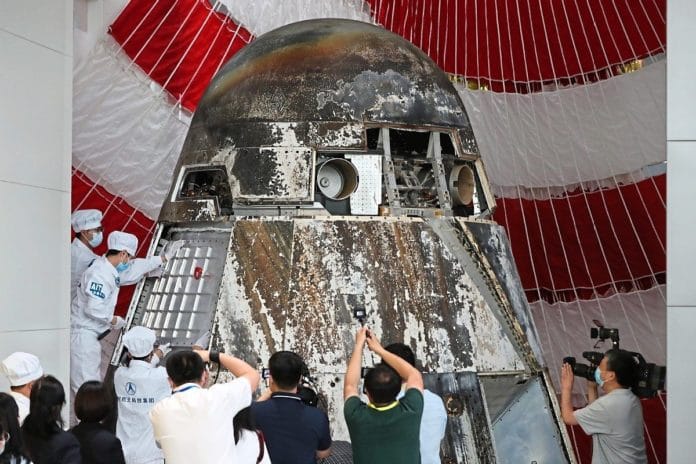 Chinese engineers open the re-entry module of the prototype of China's new-generation manned spacecraft that returned to Earth in early May, distributing items inside it to their owners, on May 29, 2020.