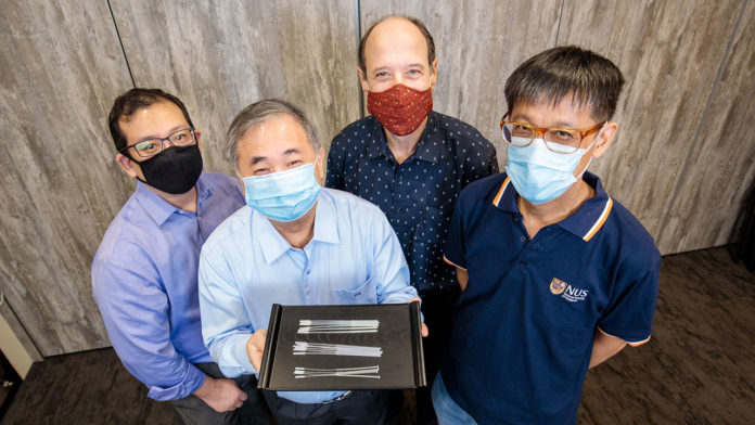 Professor Freddy Boey (centre, showing the swabs), and (from left) Dr Alfred Chia, Associate Professor David Allen, and Associate Professor Yen Ching-Chiuan are part of two NUS teams that developed three nasopharyngeal swab designs for COVID-19 testing.