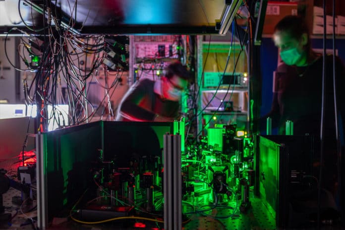 Researchers work on one of the quantum network nodes, where mirrors and filters guide the laser beams to the diamond chip