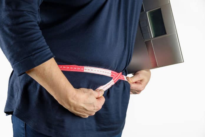 Image showing women measuring her abdominal fat using measuring tape