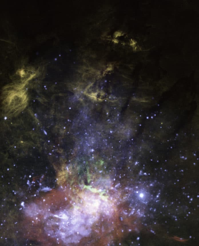 This is a composite view of X-rays, molecular gas, and warm ionized gas near the galactic center. The orange-colored features are of glowing hydrogen gas. One such feature, at the top tip of the jet (see the annotated image below) is interpreted as a hydrogen cloud that has been hit by the outflowing jet. The jet scatters off the cloud into tendrils that flow northward. Farther down near the black hole are X-ray observations of superheated gas colored blue and molecular gas in green. These data are evidence that the black hole occasionally accretes stars or gas clouds, and ejects some of the superheated material along its spin axis.