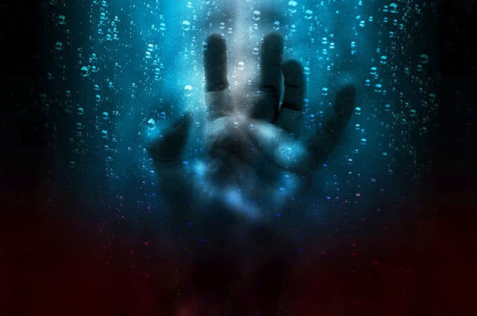 Image showing hand on glass wall with water droplets behind