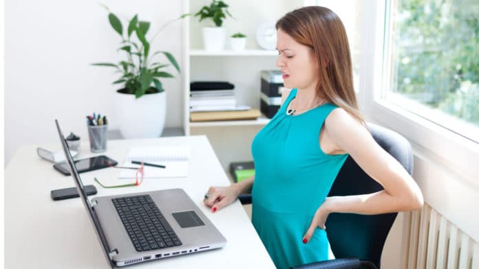 Image showing young working woman having lower back pain