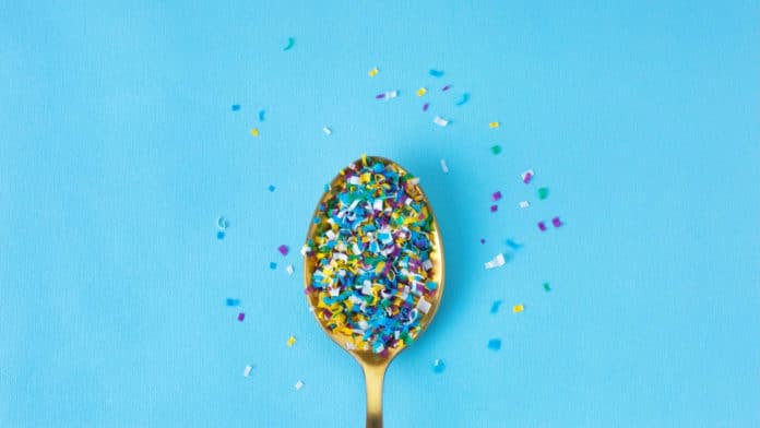microplastics in a spoon on blue background