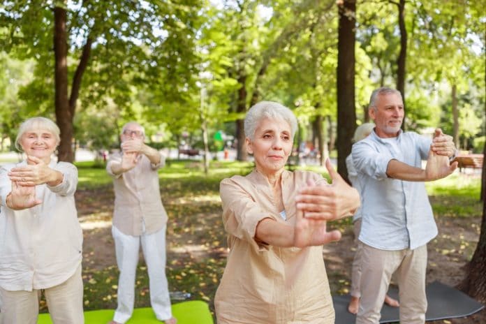 Joyful old people practicing chi kung in the park