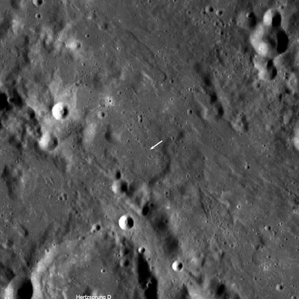The crater formed (5.226 degrees north, 234.486 degrees east, 1,863 meters elevation) in a complex area where the impact of ejecta from the Orientale basin event overlies the degraded northeast rim of Hertzsprung basin (536 kilometers diameter). The new crater is not visible in this view, but its location is indicated by the white arrow. LROC WAC mosaic, 110 kilometers width.