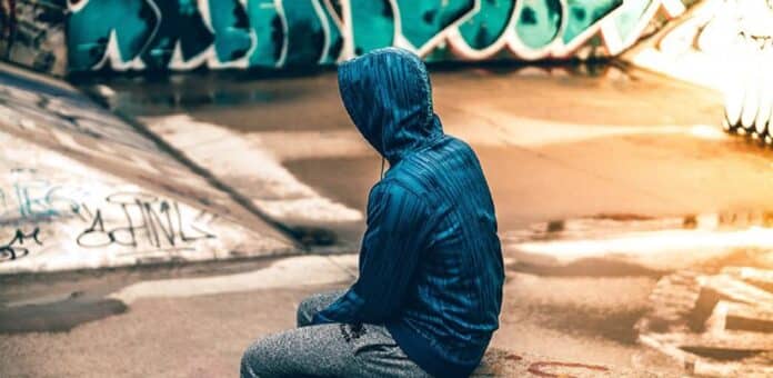 Image showing Teenager sitting near graffiti.