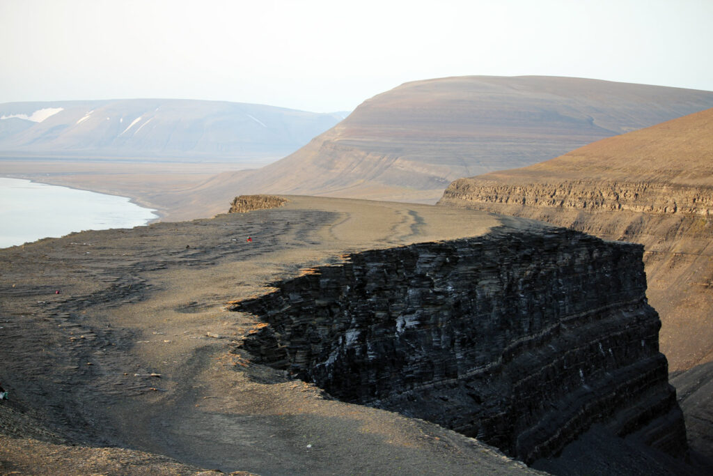 An overlook of the Muen plateau as seen from the Muen mountain on Edgeøya, Svalbard. Marine reptiles are spread out across the plateau. Author VSE in red jacket for scale.