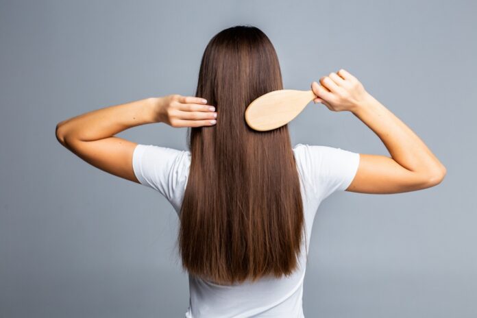 Image showing a girl combing her hair.