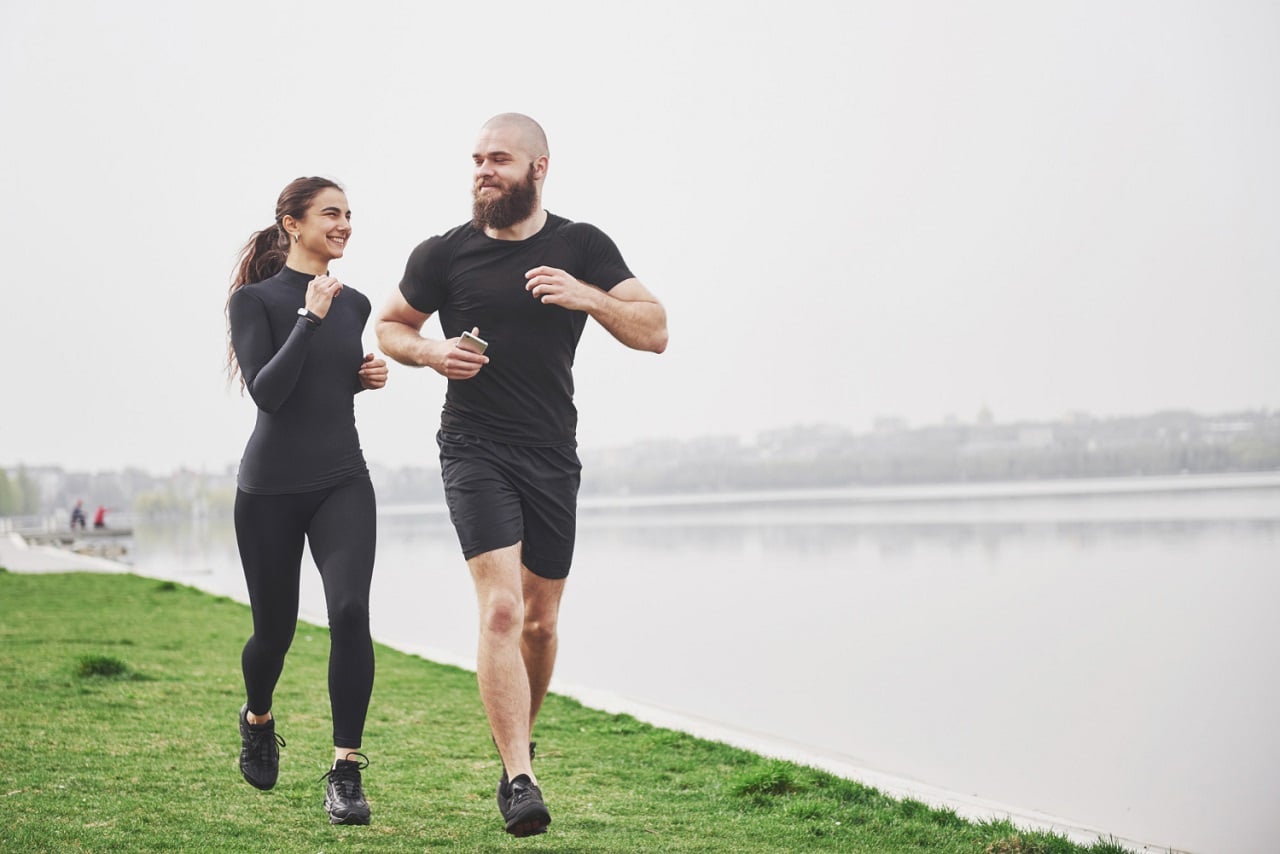 Image showing couple jogging and running outdoors in park near the water.
