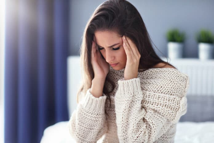 Adult woman suffering from headache at home