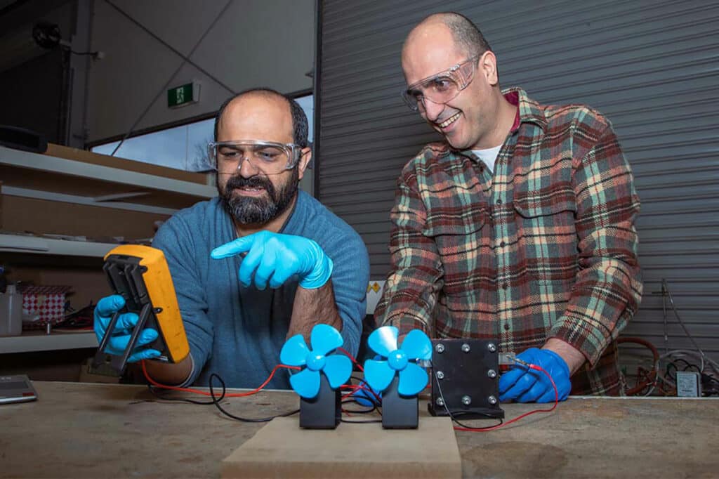 Dr. Shahin Heidari (left) and Dr. Seyed Niya with the proton battery operating two small fans in the RMIT lab.