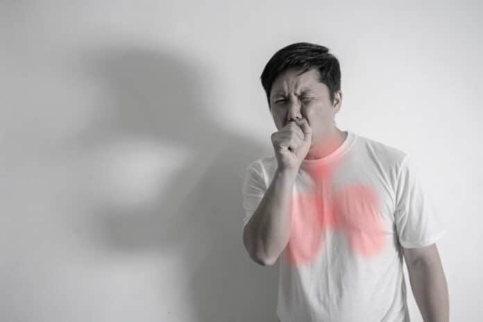 Image showing man coughing into his fist isolated on a white background.