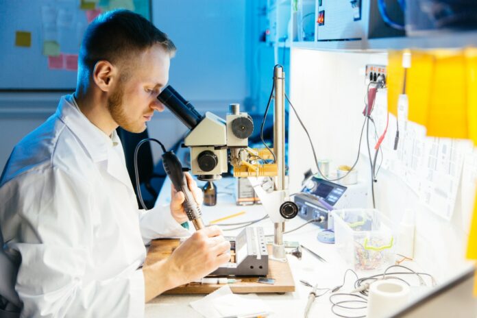 Electronic laboratory worker working with microscope