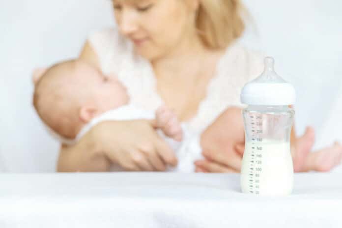 Image showing mother feeding baby from bottle