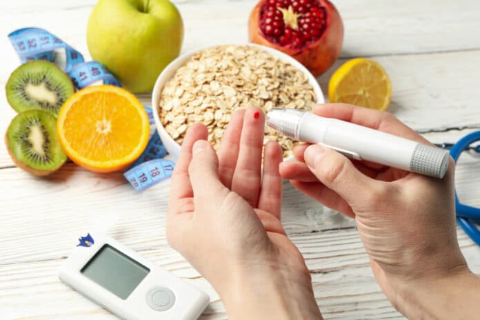 Female checking blood sugar level on table with diabetic accessories