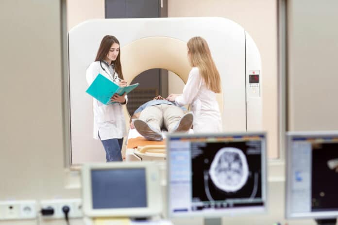Mri machine and screens with doctor and nurse