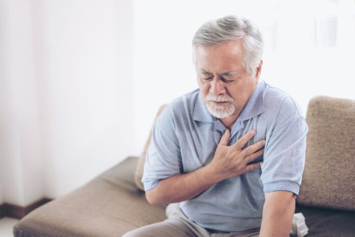 Senior male asian suffering from bad pain in his chest heart attack at home